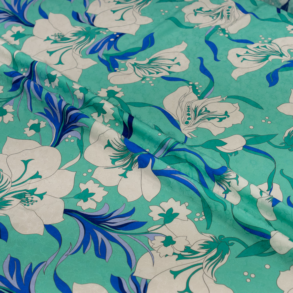 Floral fabric with blue and white flowers on a teal background