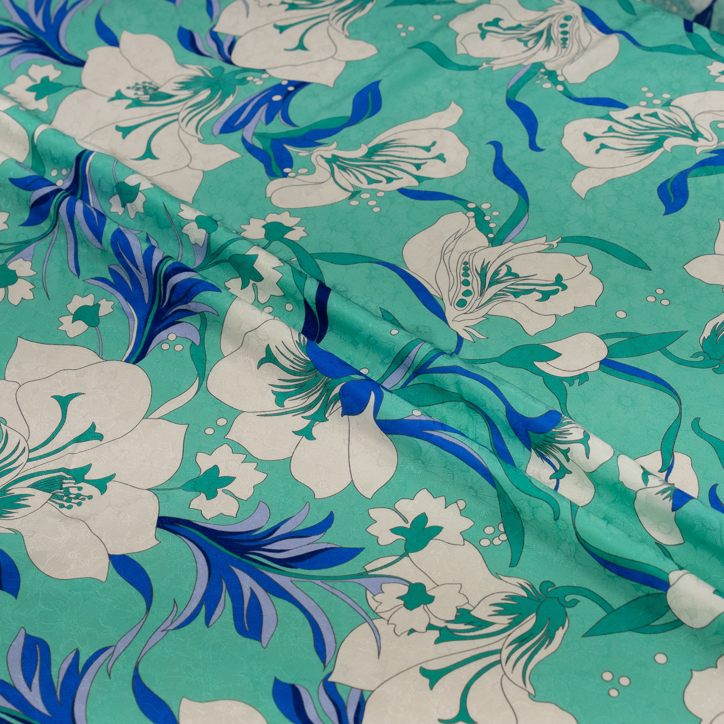 Floral fabric with blue and white flowers on a teal background