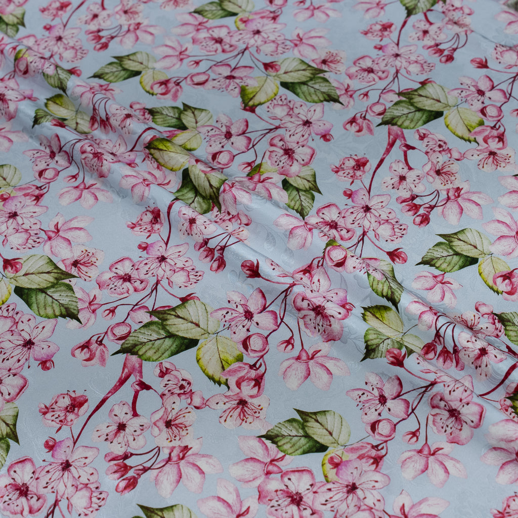 Floral pattern with pink flowers and green leaves on a light blue background