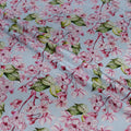 Floral pattern with pink flowers and green leaves on a light blue background