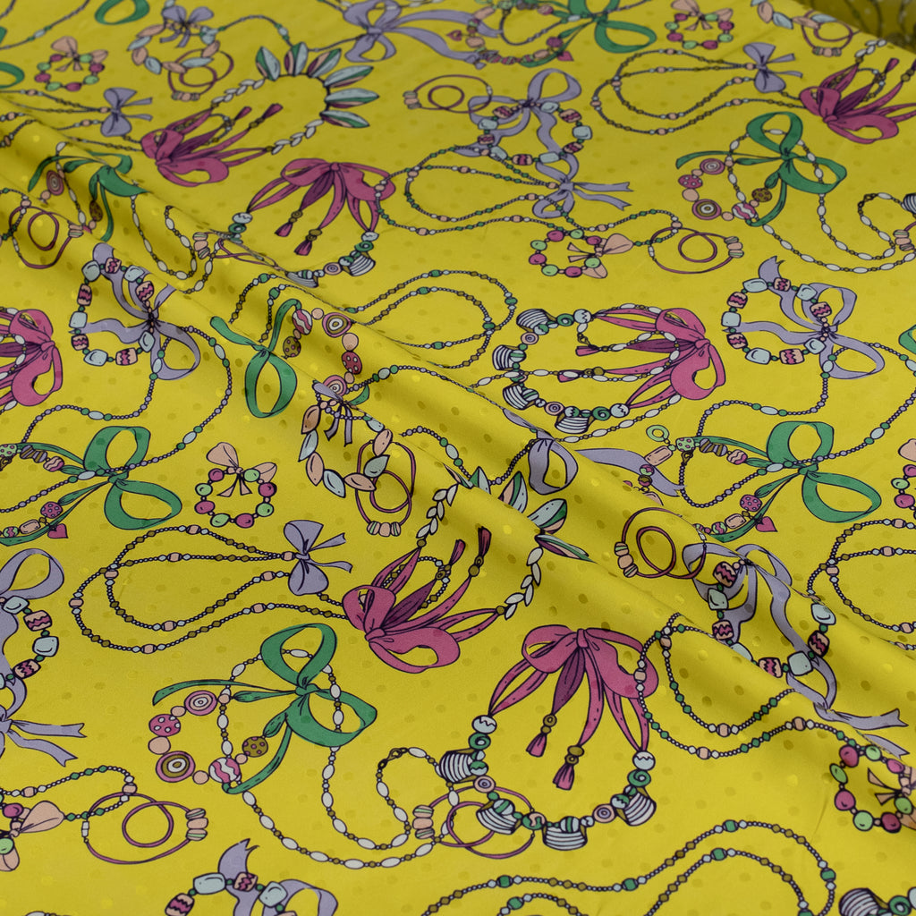 Colorful jewelry patterns on a yellow fabric background