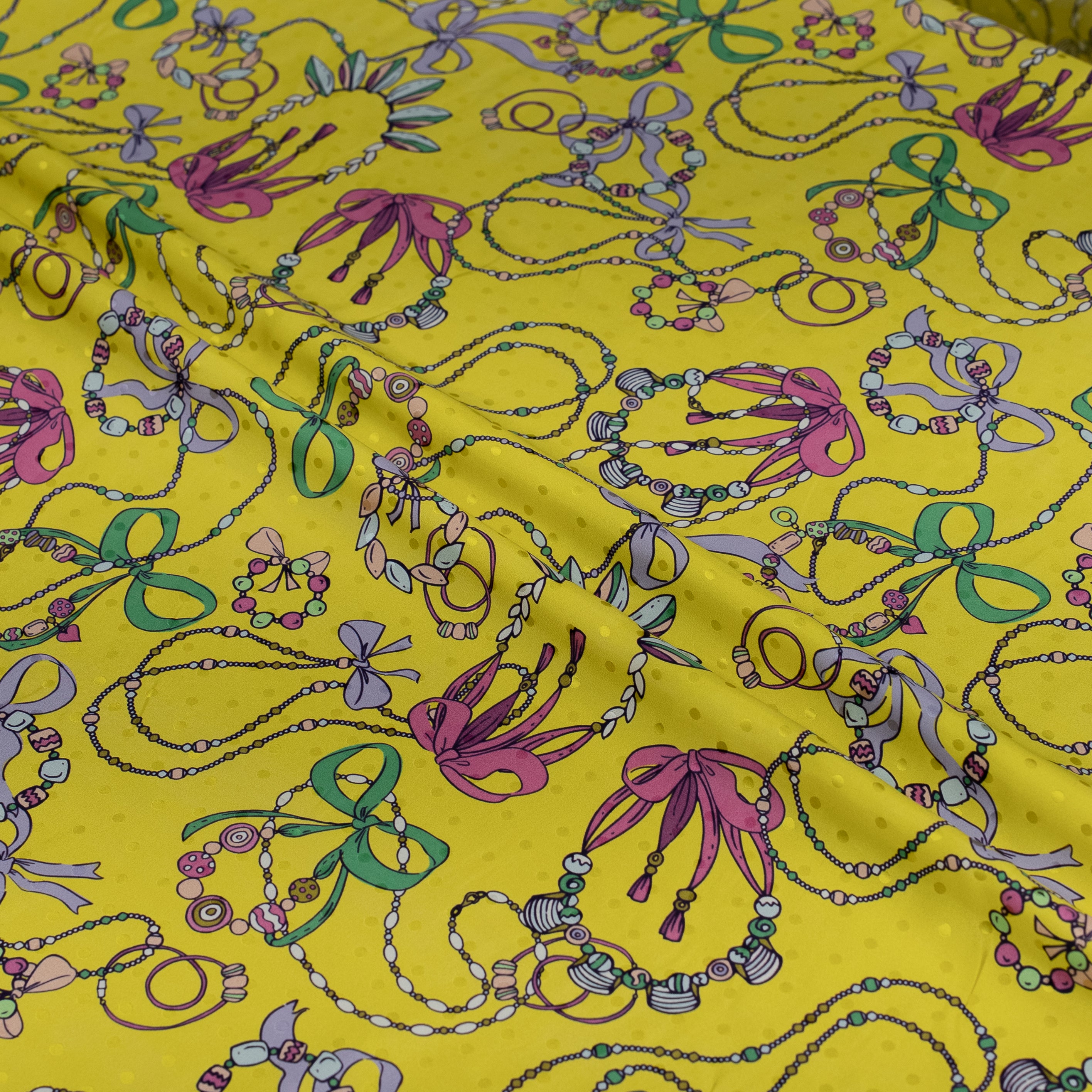 Colorful jewelry patterns on a yellow fabric background