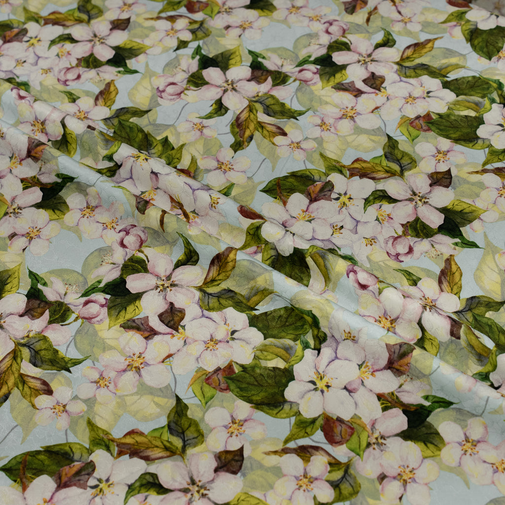 Floral pattern with pink flowers and green leaves on a light blue background