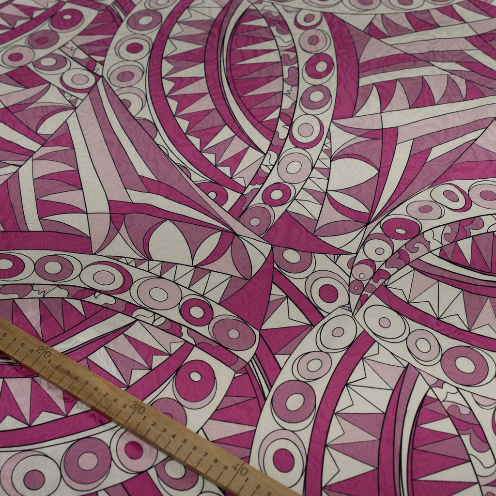 Pink and white geometric patterned fabric with a ruler for scale.