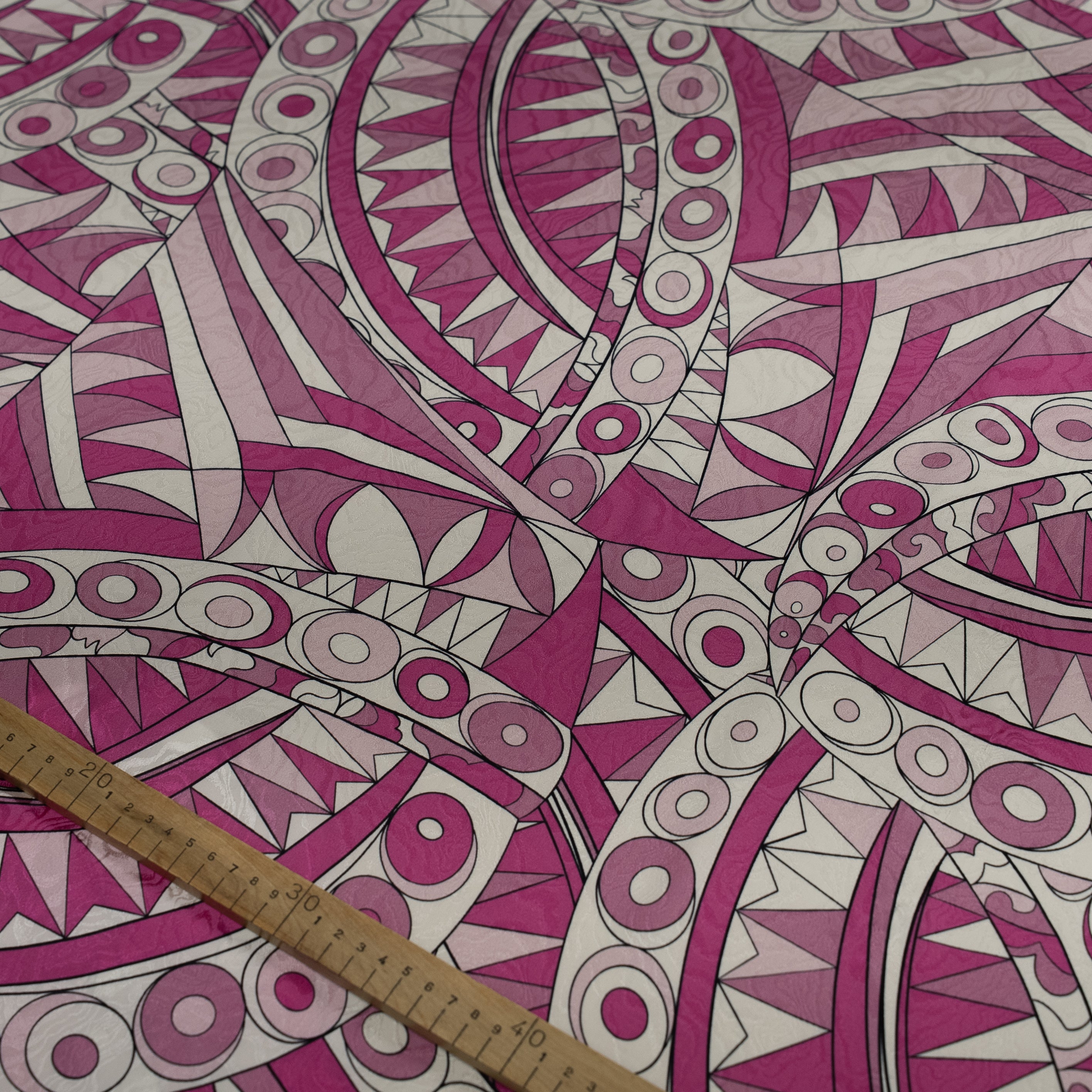 Pink and white geometric patterned fabric with a ruler for scale.
