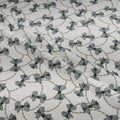 Patterned fabric with small bows and chain designs on a white background