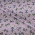 Fabric with a pattern of green bows and gold chains on a white background