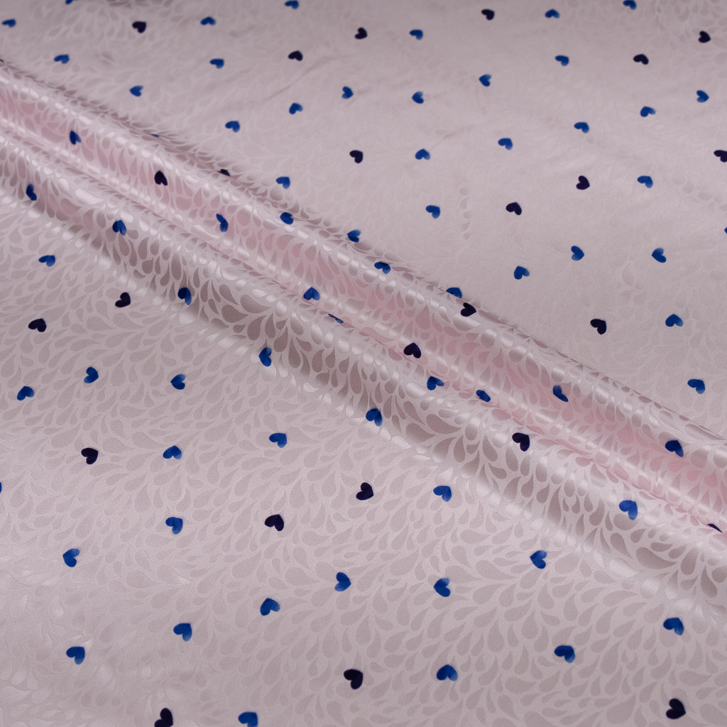 Fabric with blue and black heart patterns on a light background