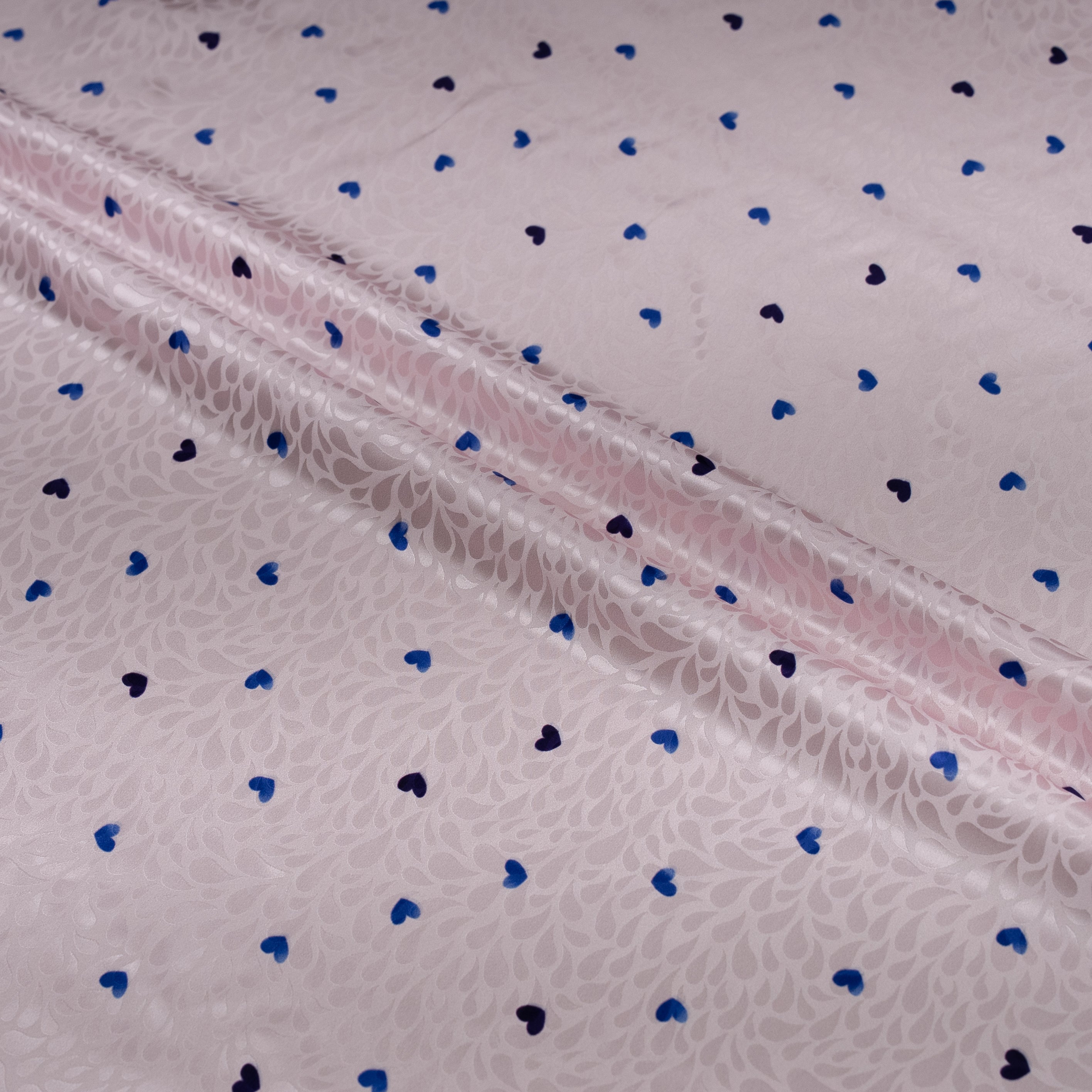 Fabric with blue and black heart patterns on a light background