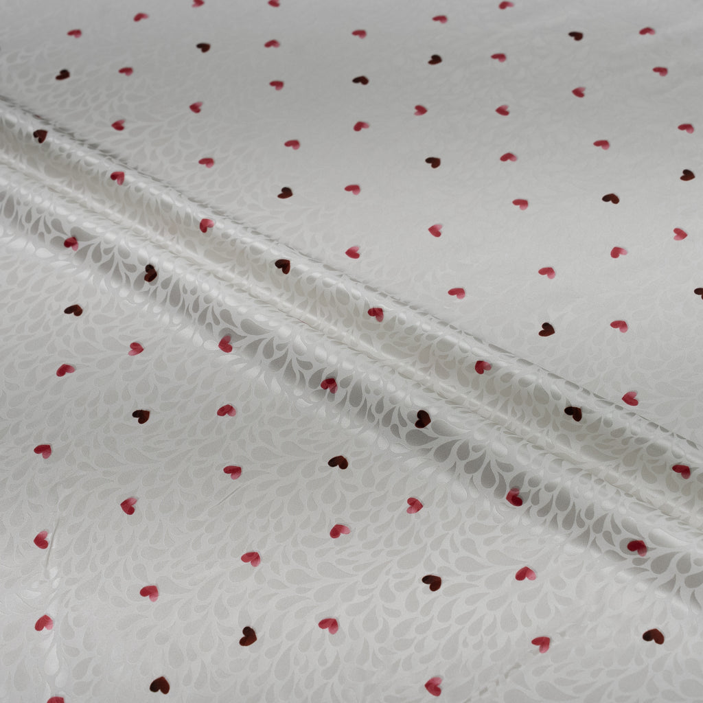 White fabric with red heart patterns and lace trim