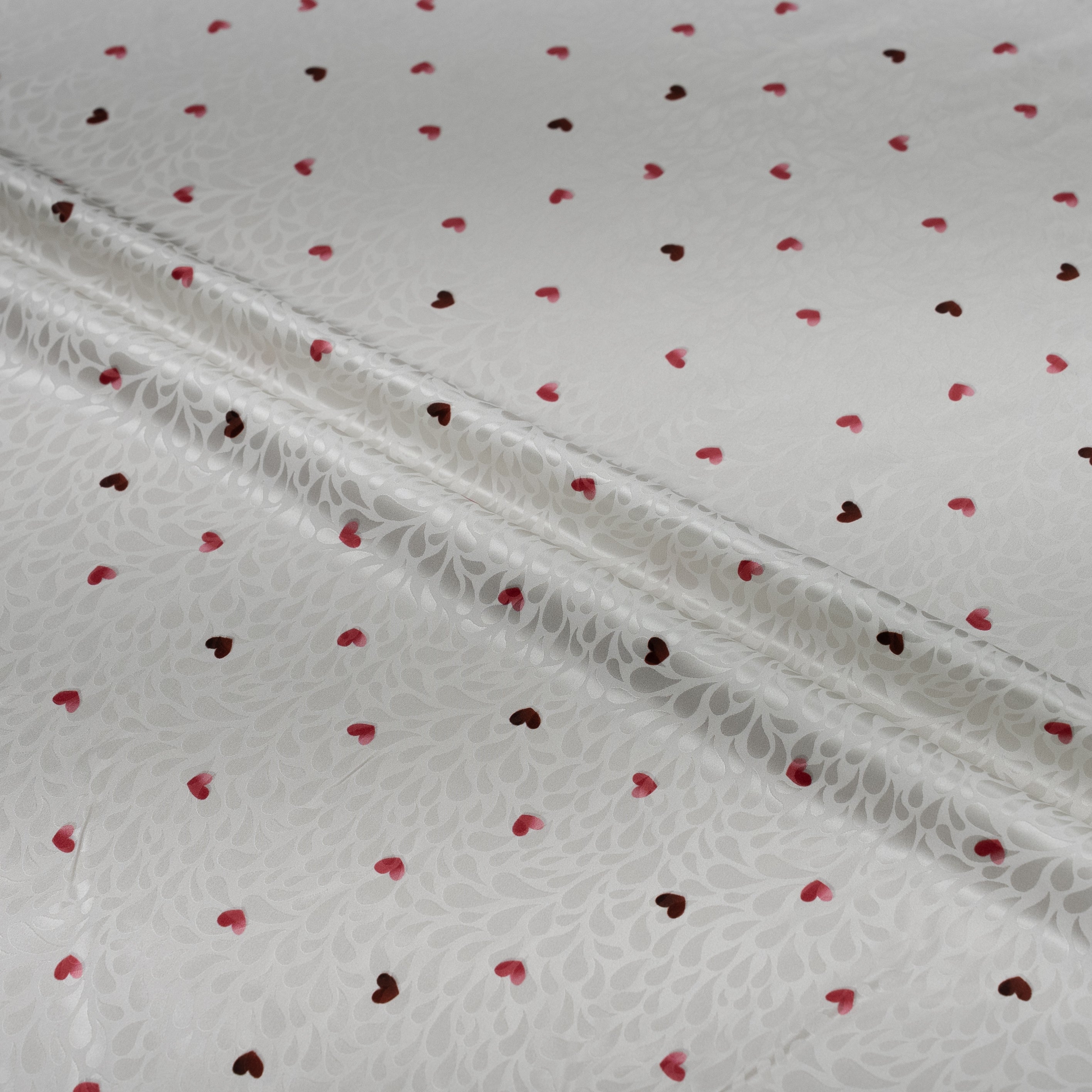 White fabric with red heart patterns and lace trim