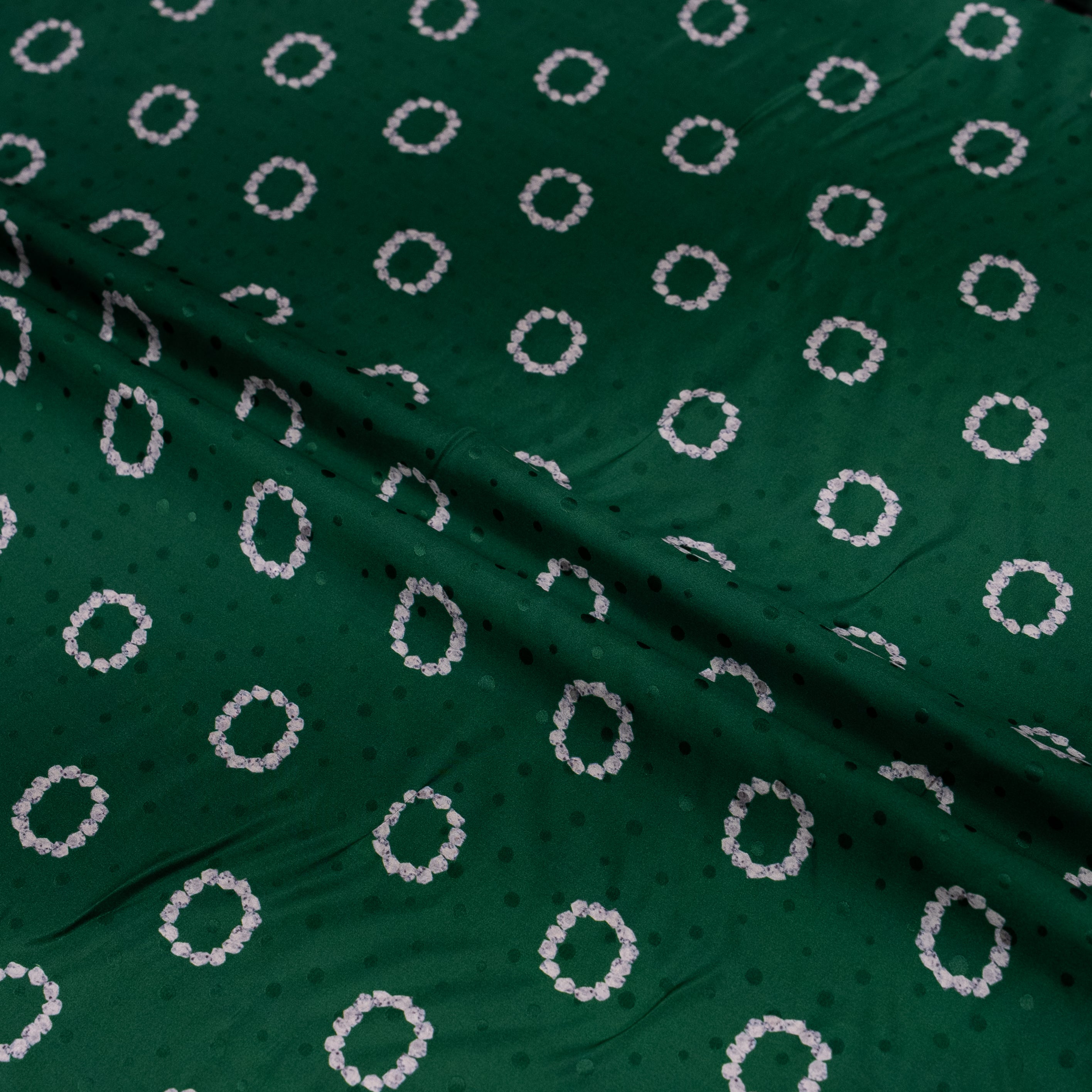 Green fabric with white circular pattern