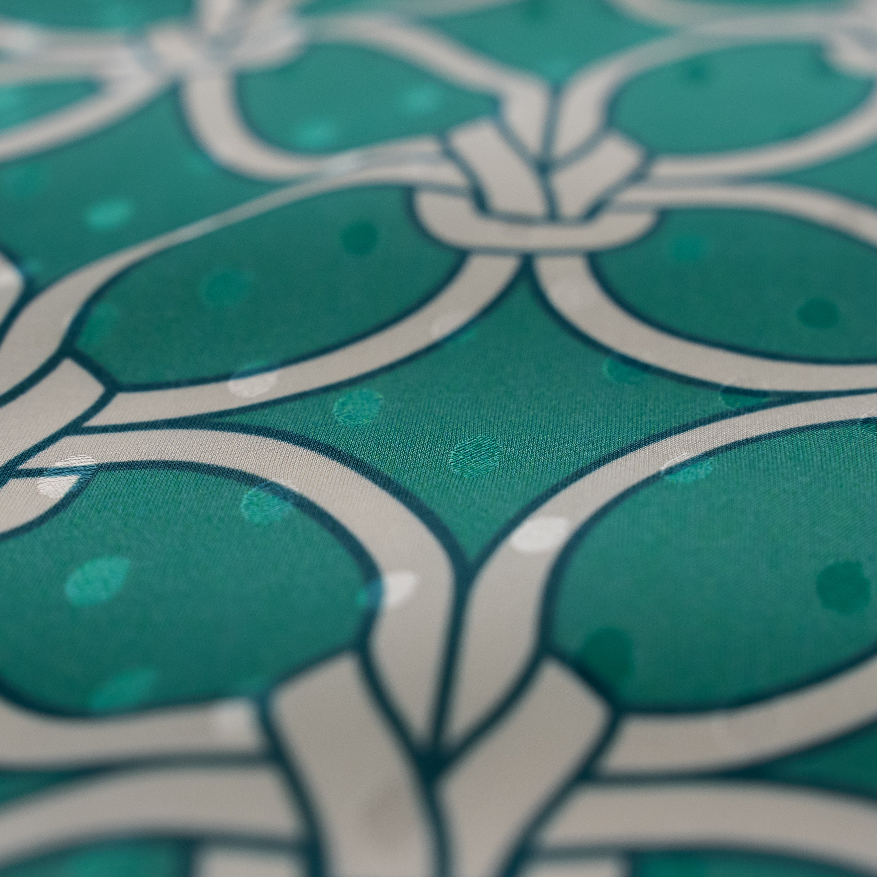 Close-up of a teal fabric with white geometric pattern
