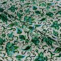 Green floral patterned fabric on a white background
