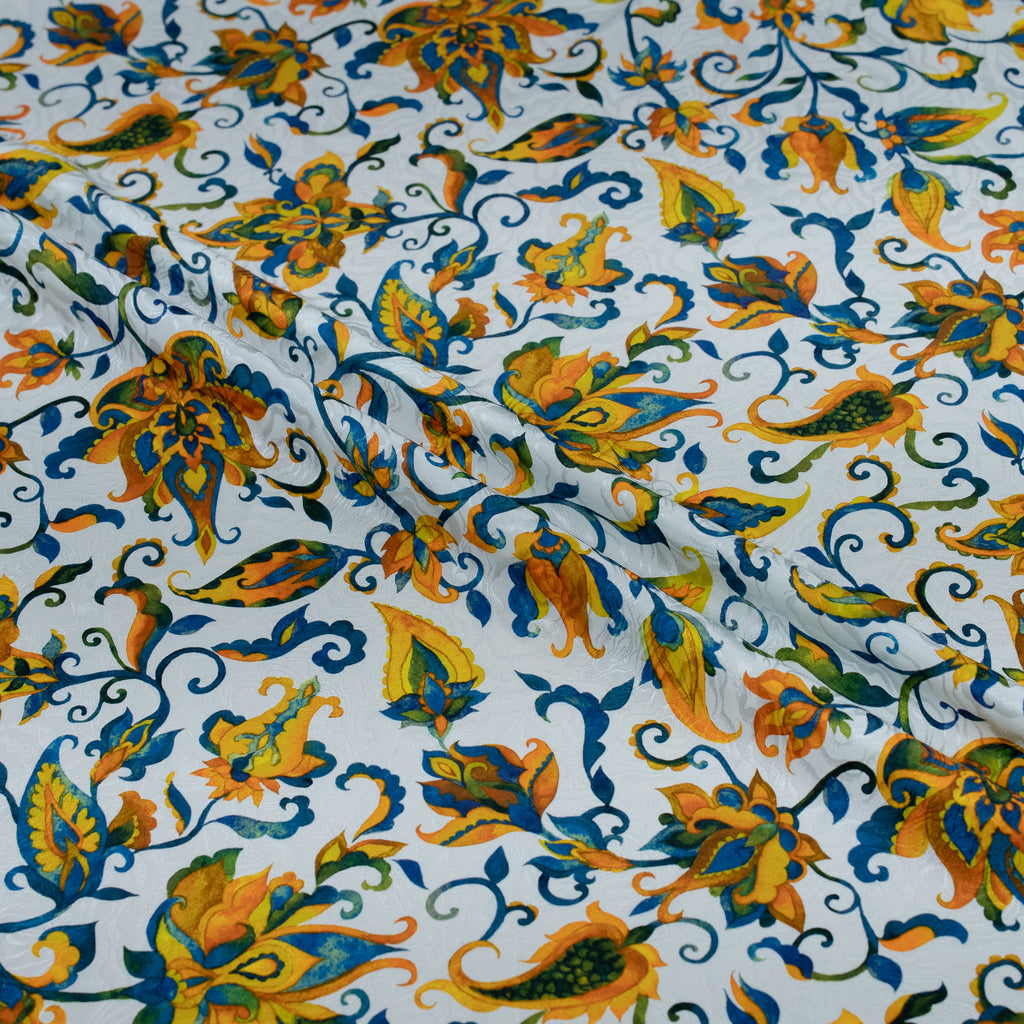 Floral patterned fabric with orange, blue, and green colors on a white background
