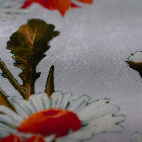 Close-up of floral embroidery on fabric with a textured background