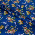 Floral patterned fabric with colorful flowers on a blue background